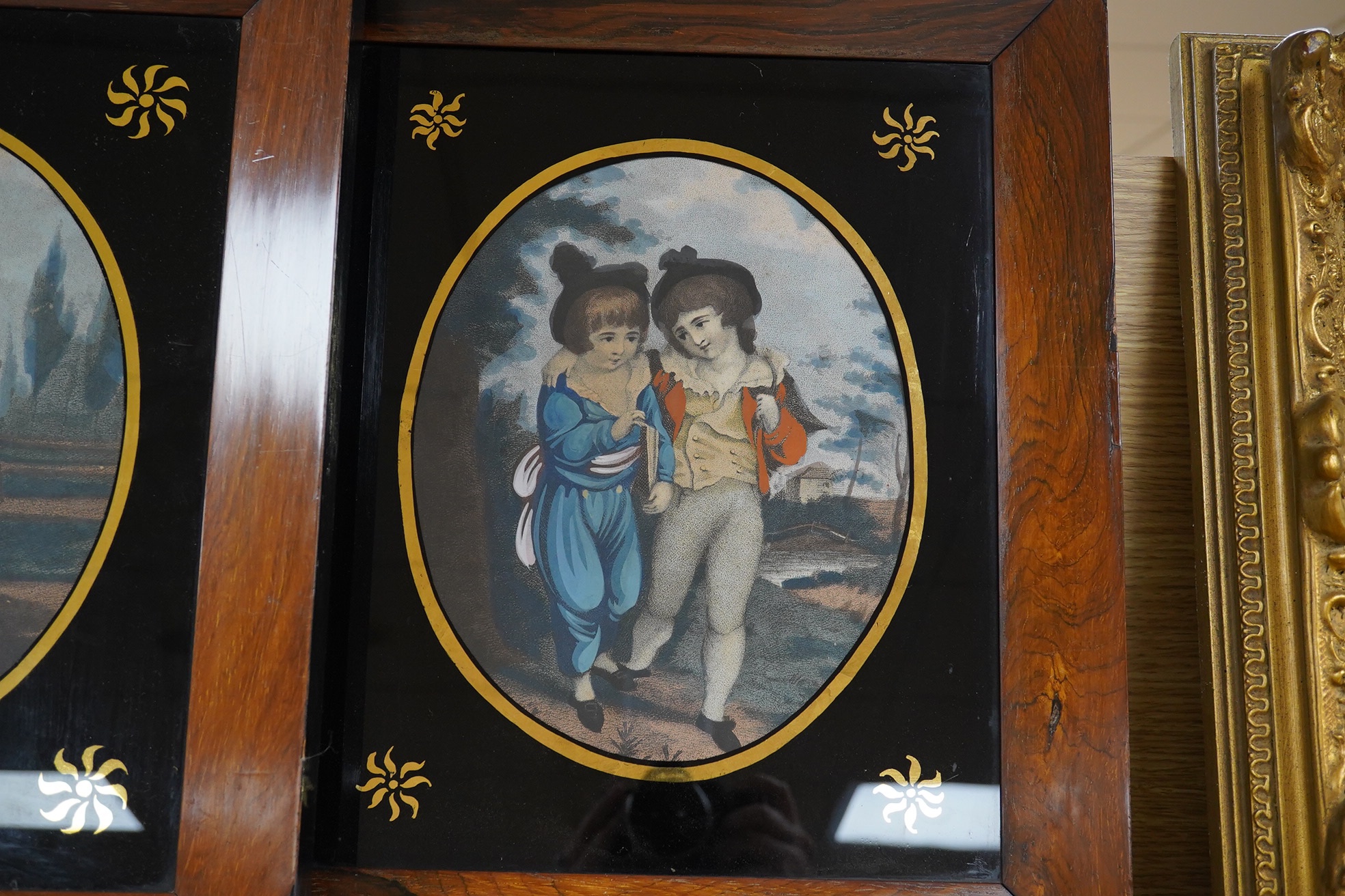 Early 19th century, pair of Verre eglomise prints, Children before landscapes, each 24 x 19cm. Condition - fair, some losses to the frame